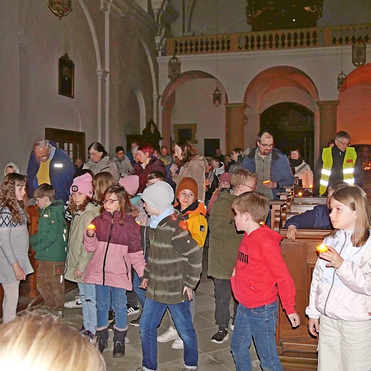 Foto in der Kirche. Die Kinder und Erwachsenen halten sich an den Händen.