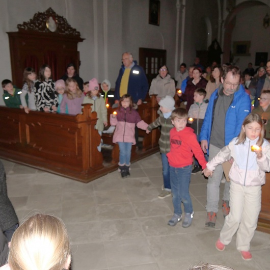 In der Kirche halten sich Kinder und Erwachsene an den Händen und beten