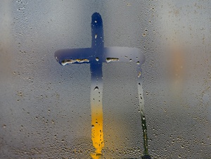 Kreuzzeichen an einem beschlagenen Fenster